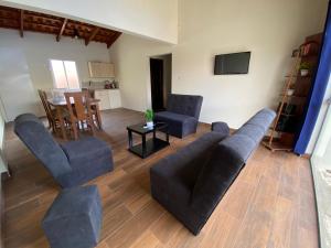 ein Wohnzimmer mit einem Sofa, Stühlen und einem Tisch in der Unterkunft Agradable departamento con estacionamiento gratis in Sucre