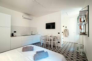 a white room with a bed and a kitchen at Cesare 22 - The House Of Travelers in Como