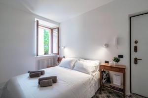 a bedroom with a white bed with two pillows on it at Cesare 22 - The House Of Travelers in Como
