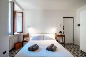 a bedroom with a large white bed with two pillows on it at Cesare 22 - The House Of Travelers in Como