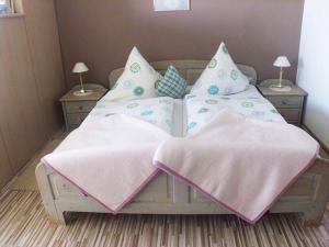 バート・ビルンバッハにあるAppartementhaus Viktoriaのベッドルーム1室(ピンクとブルーの枕が備わるベッド1台付)