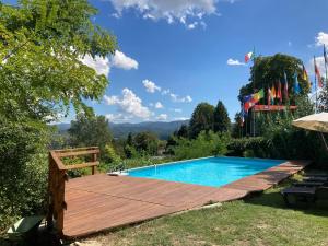 een zwembad in de achtertuin met een houten terras en een zwembad bij Casa Caroline in Ovada