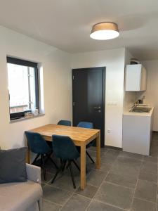 eine Küche und ein Esszimmer mit einem Holztisch und Stühlen in der Unterkunft Sunshine Apartments Golte E4 in Mozirska Koča