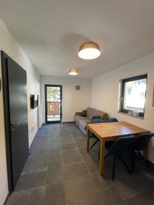 sala de estar con mesa y sofá en Sunshine Apartments Golte E4, en Mozirska Koča