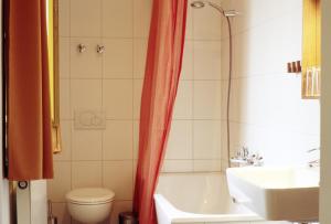 a bathroom with a tub and a toilet and a sink at Bio Hotel Kipperquelle in Weimar