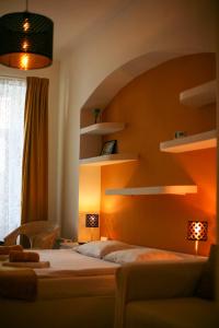 een slaapkamer met een oranje muur met planken en een bed bij Black Church Studio in Braşov