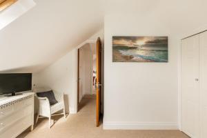 sala de estar blanca con TV y sofá en Eighteen Whitstable 4 parking spaces, en Kent