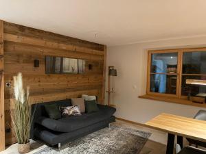 - un salon avec un canapé et un mur en bois dans l'établissement Ferienwohnung Ottobeuren, à Ottobeuren