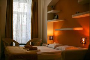 una camera da letto con un letto con due asciugamani sopra di Black Church Studio a Braşov