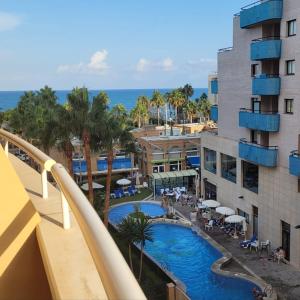 een balkon met uitzicht op het zwembad van een resort bij Apartamento en 7ᵃ Planta - 1ᵃ Línea de Playa - Bahía Park, Marina d'Or in Oropesa del Mar