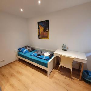 a small bedroom with a bed and a desk at Town House Rosenheim in Rosenheim