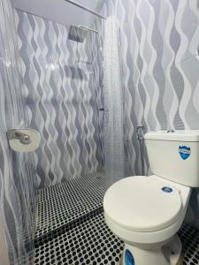 a bathroom with a toilet and a shower curtain at Cabuhat Duco Lodge 2 in Naic