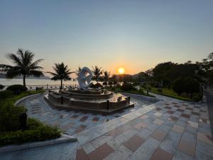 uma estátua num parque com o pôr-do-sol ao fundo em Cat Ba Bay Vision Hotel em Ilha de Cát Bà