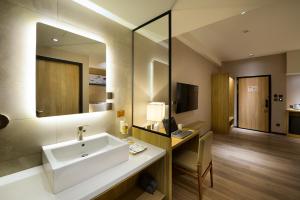 a bathroom with a sink and a desk and a mirror at Joyfultel in Guishan +22 photos
