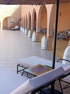 a row of tables and chairs in a building at Hotel Riad Ali in Merzouga