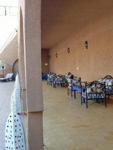 a row of chairs in a large room with a row of tables at Hotel Riad Ali in Merzouga