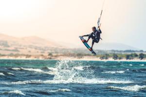 a man in the air on a board in the water at Keros Blue - Luxury in Wilderness in Kalliópi