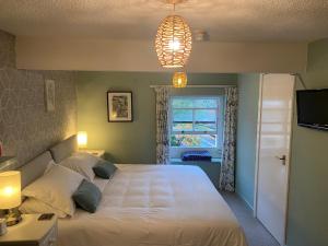 Un dormitorio con una gran cama blanca y una ventana en Talbot House Bed & Breakfast and Tearoom en Pateley Bridge