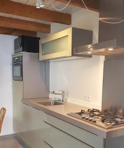 een keuken met een wastafel en een fornuis top oven bij Ferienhaus Noordwijk Zee & Strand in Noordwijk