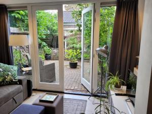 een woonkamer met een deur naar een patio bij Ferienhaus Noordwijk Zee & Strand in Noordwijk