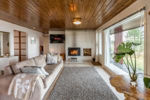 a living room with a couch and a fireplace at Lapland Sunrise Cottage with lakefront Sauna in Rovaniemi +37 photos