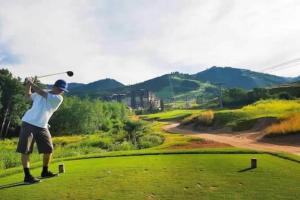 a man swinging a golf club on a golf course at Red Pine Mountain Retreat steps from the Cabriolet in Park City