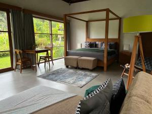 a bedroom with a bed and a table with a desk at Uma Mupu Retreat in Gianyar