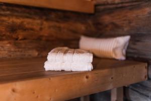 a stack of towels sitting on a wooden table at Lapland Northern Lights Cabin - Wooden Sauna in Rovaniemi