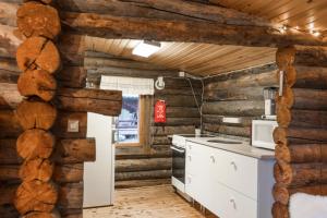 a kitchen with wooden walls and white appliances at Lapland Northern Lights Cabin - Wooden Sauna in Rovaniemi