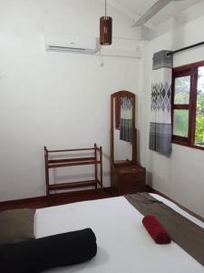 sypialnia z 2 łóżkami, lustrem i oknem w obiekcie Grand Nest Bay Resort w mieście Weligama
