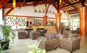 a restaurant with wicker chairs and tables in a building at Ocean Bay Hotel & Resort in Bathurst