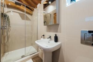 y baño blanco con lavabo y ducha. en The Honeybee's Nest - Semi-rural Barn Conversion close to Leavesden Studios, en Leverstock Green