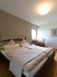 ein großes weißes Bett in einem Zimmer mit Fenster in der Unterkunft Ferienwohnung Auszeit in Losheim