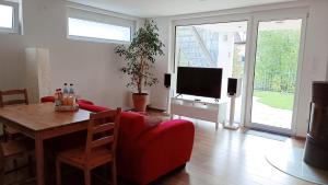 a living room with a red couch and a tv at Apartment Baumeister in Weilheim an der Teck