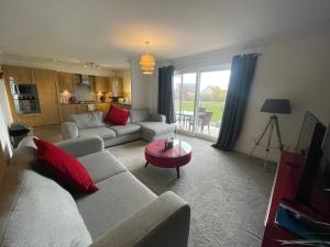 a living room with a couch and a table at The Duplex Nairn- Spacious 3 Bedroom with sunny balcony in Nairn
