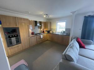 a living room with a couch and a kitchen at The Duplex Nairn- Spacious 3 Bedroom with sunny balcony in Nairn