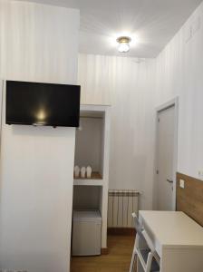 uma sala de estar com uma televisão na parede em Hostal Esparteros em Madri