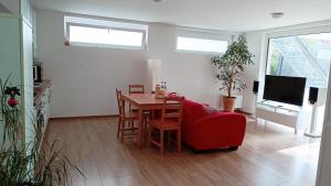 ein Wohnzimmer mit einem Tisch und einem roten Stuhl in der Unterkunft Apartment Baumeister in Weilheim an der Teck