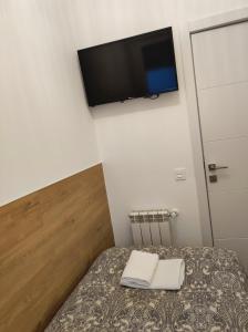 a bedroom with a bed with a tv on the wall at Hostal Esparteros in Madrid