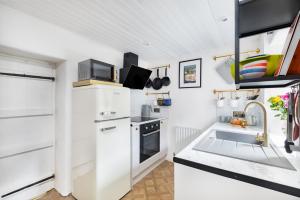 a kitchen with white cabinets and a stove top oven at No 9 The Hill Cromford Nr Matlock Bath in Cromford
