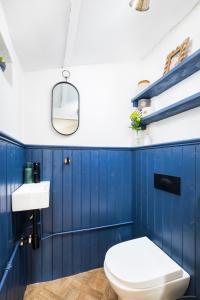 a blue bathroom with a toilet and a sink at No 9 The Hill Cromford Nr Matlock Bath in Cromford
