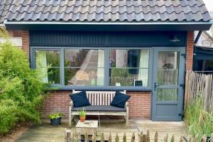 ein Haus mit einer blauen Tür und einer Bank auf einer Terrasse in der Unterkunft Zilt Noordwijk in Noordwijk aan Zee