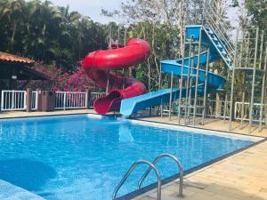 a swimming pool with a water slide in a resort at Hotel Bosques do Massaguaçu in Caraguatatuba