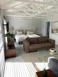 a living room with a couch and a bed at Cozy spacious loft on 4th Avenue in Cape Town