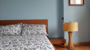 ein Bett mit Kissen und eine Lampe im Schlafzimmer in der Unterkunft Casa Turati in Turin