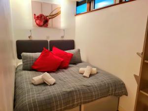 a bedroom with a bed with red and white pillows at Newton Apartment nr Wigan Hospital in Wigan