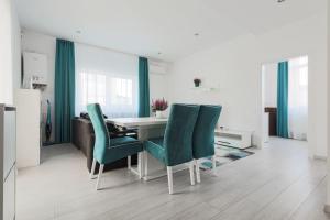a dining room with a table and green chairs at Ambassador Apartment in Baia Mare