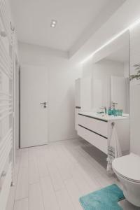 a white bathroom with a sink and a toilet at Ambassador Apartment in Baia Mare