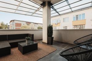 a patio with a couch and chairs on a balcony at Ambassador Apartment in Baia Mare