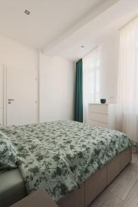 a bedroom with a bed with a green and white blanket at Ambassador Apartment in Baia Mare